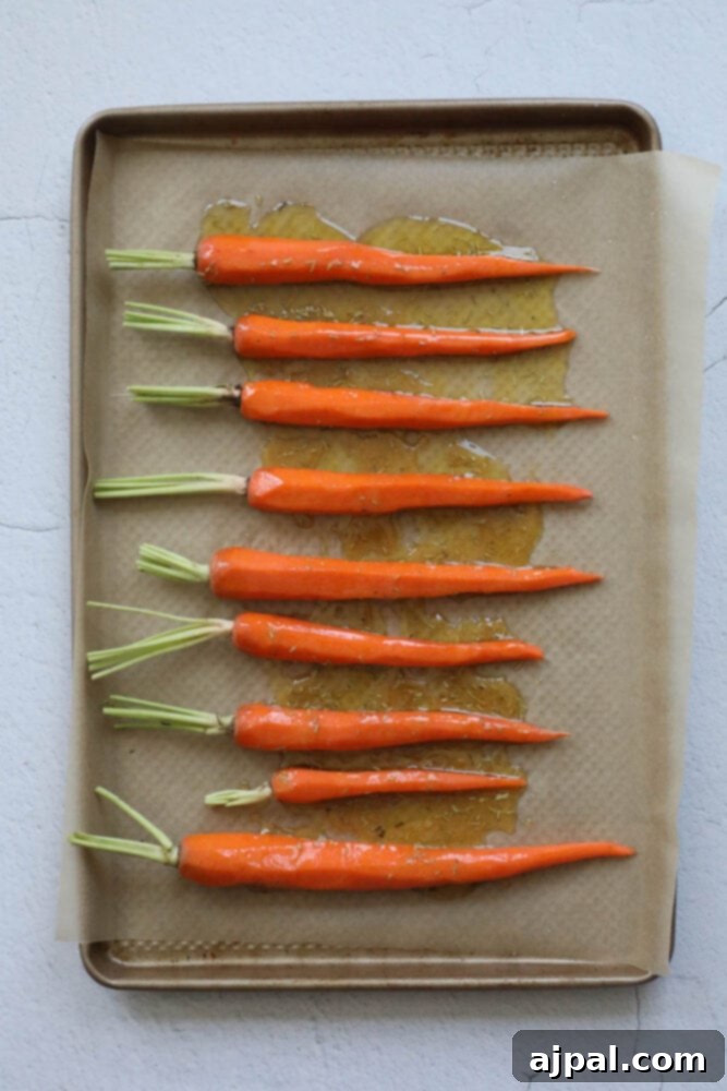 picture of seasoned raw carrots on parchment paper