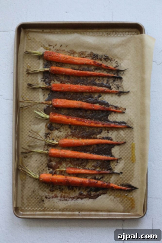 picture of roasted carrots on parchment paper on a baking sheet