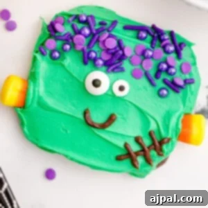 picture of chocolate dipped cookies, covered in green icing with purple sprinkles for hair, candy corn neck bolts, candy eyes, and an icing smile to look like frankenstein