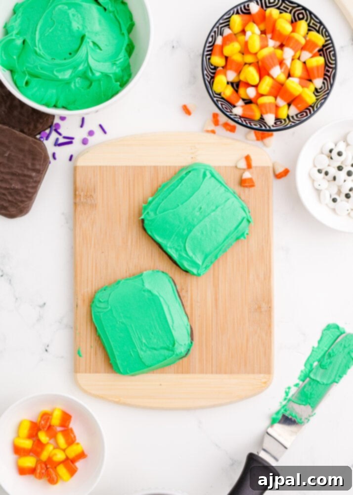 Spooky Frankenstein Cookies 7 Several rectangular chocolate cookies uniformly covered in vivid green icing, laid out for the next decorating step.