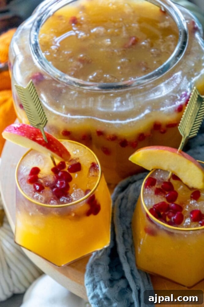 A close-up of a vibrant pomegranate and pumpkin punch, showcasing its rich autumn colors.