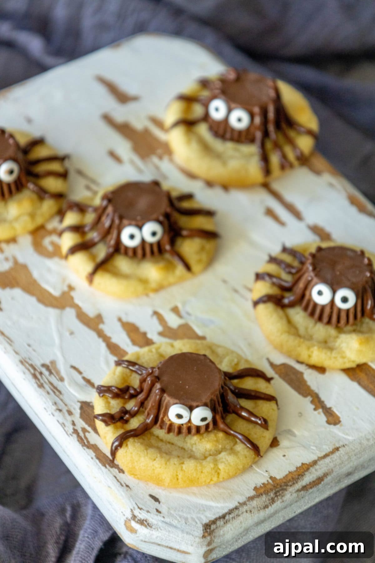 Spooky Spider Cookies 10 Finished spider cookies displayed on a wooden cutting board, ready for serving at a Halloween gathering.