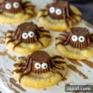 picture of cookies on a cutting board with peanut butter cups decorated to look like spiders on top