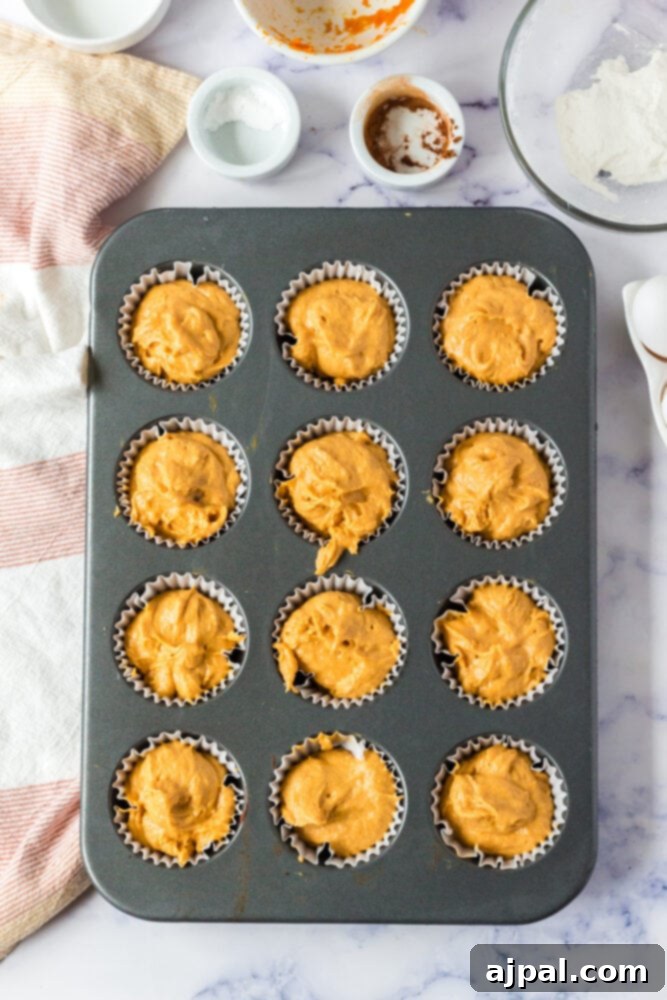 picture of pumpkin muffin batter in cupcake liners in a cupcake tin