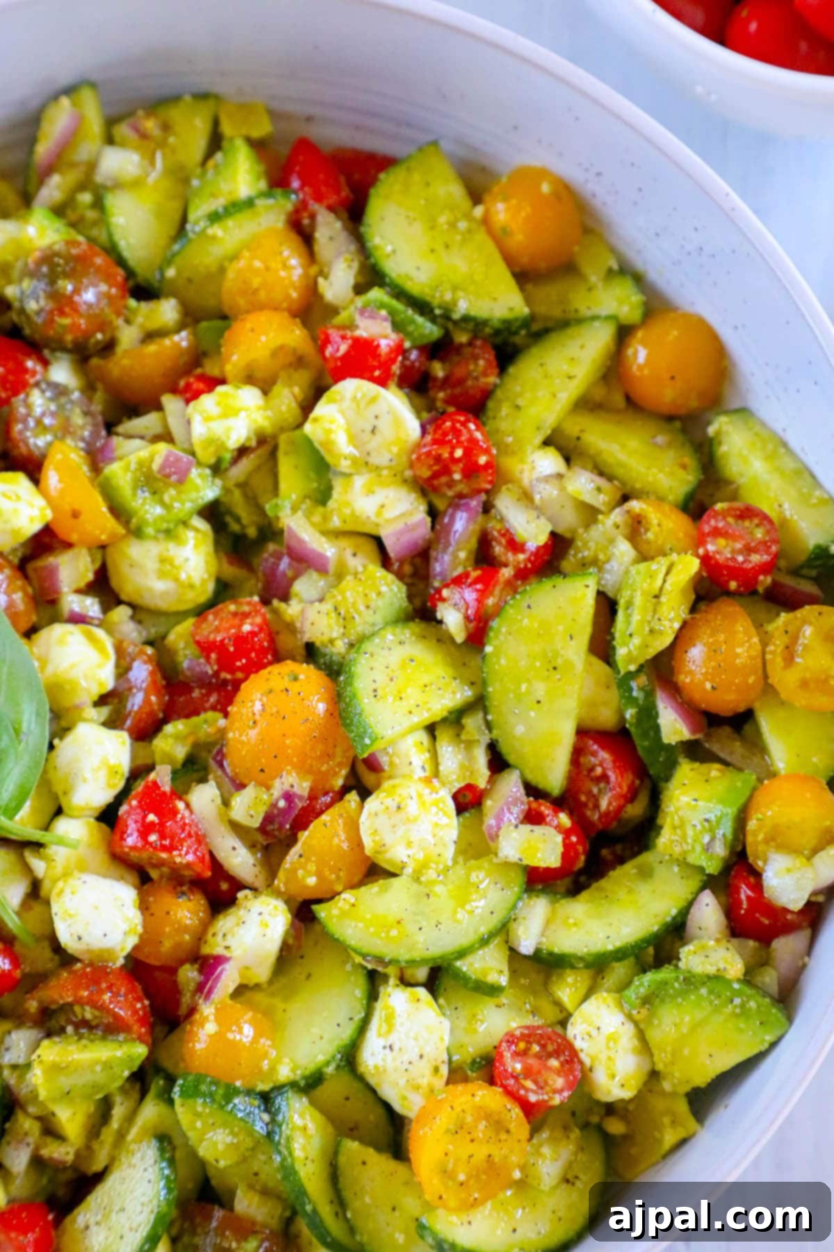 Vibrant Pesto Caprese 4 A vibrant bowl of cucumber salad, enriched with ripe tomatoes and fresh basil, perfectly inspired by the rich and aromatic pesto caprese recipe.