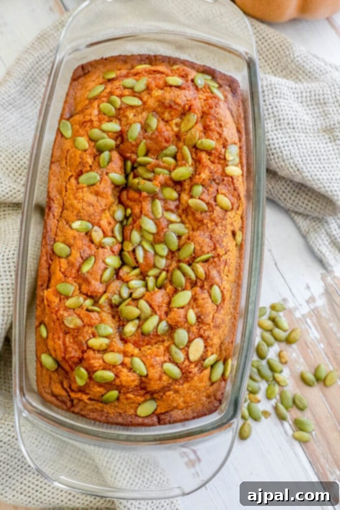 Starbucks-Inspired Pumpkin Bread 5 Spicy pumpkin bread baked in a glass dish, topped with pumpkin seeds.