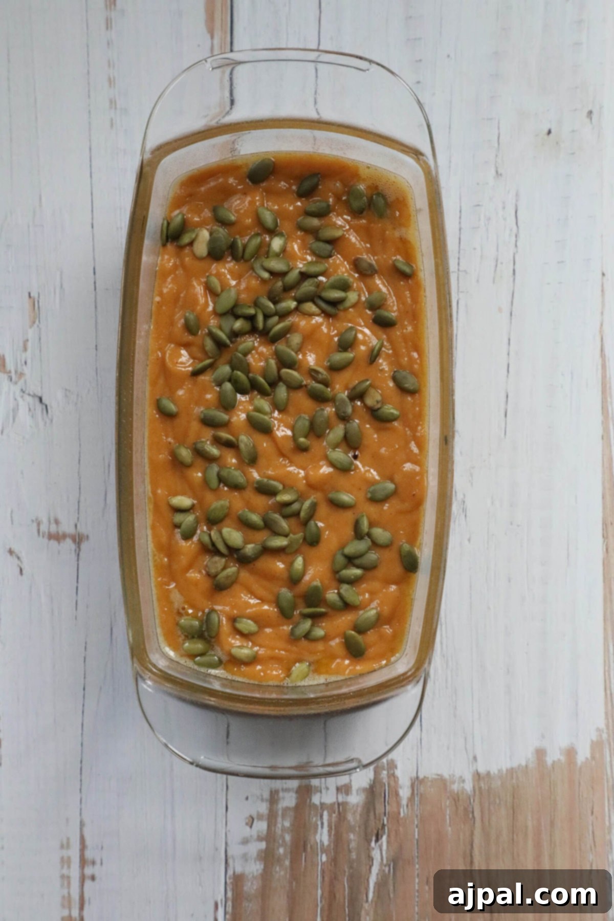 Starbucks-Inspired Pumpkin Bread 8 A glass dish with pumpkin seeds for a pumpkin loaf recipe.