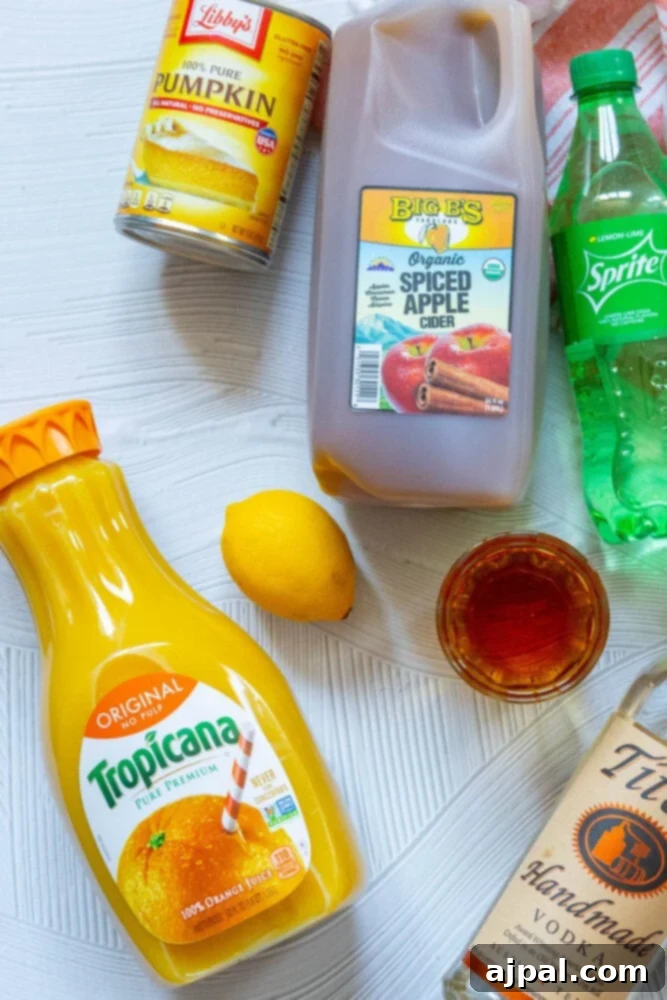 A collection of ingredients for Sparkling Pumpkin Punch, including bottles of orange juice, lemon juice, and various spices, arranged on a rustic wooden table.