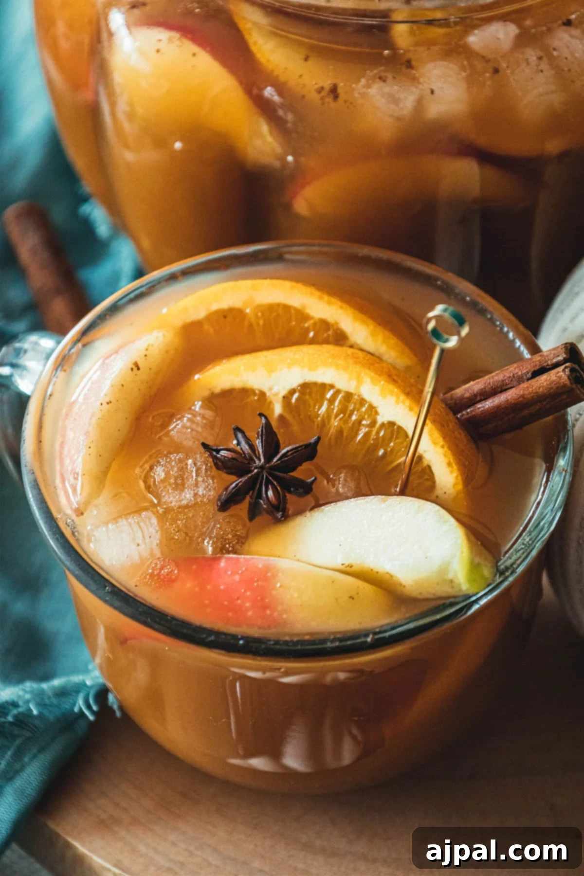 A large bowl of sparkling apple cider punch, elegantly garnished with cinnamon sticks and fresh apple slices, reflecting the autumn season.