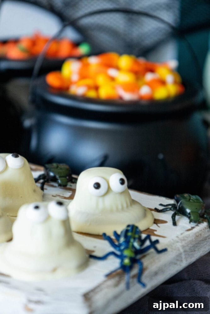 A tray of White Chocolate Dipped Ghost Cookies with candy surprises inside.