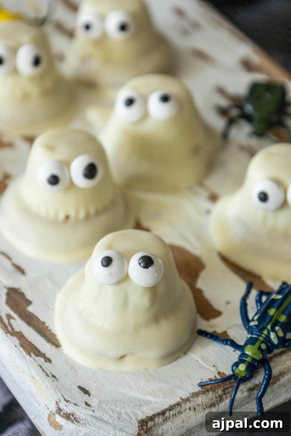 A tray of white ghost cookies adorned with eyes, made using a white chocolate ghost cookies recipe.