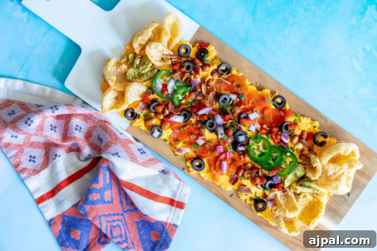 picture of pub cheese spread on a board covered with pork rinds, jalapenos, olives, bacon crumbles, peanuts, pimiento peppers, chives, red onion, and pepperoni