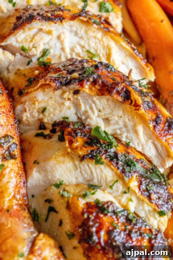 Foolproof & Delicious Roast Chicken 4 The Best Easy Roast Chicken presented whole on a platter, surrounded by vibrant roasted carrots and fresh parsley sprigs.