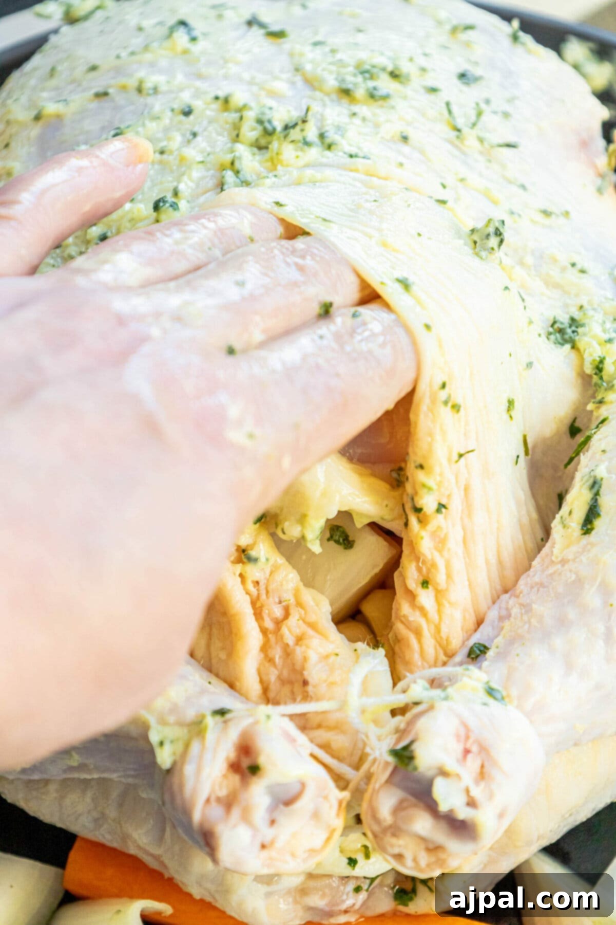 Effortless Perfect Roast Chicken 6 A person effortlessly removing a chicken from a pan while following The Best Easy Roast Chicken recipe.
