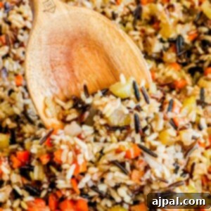 A wooden spoon rests within a hearty serving of wild rice pilaf, showcasing the rich texture and appealing presentation of the dish.