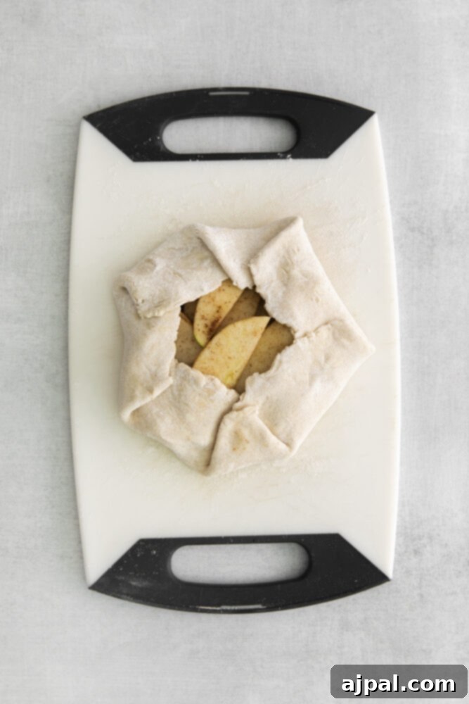 An assembled apple galette, showcasing its rustic edges and exposed apple filling, ready to be baked.