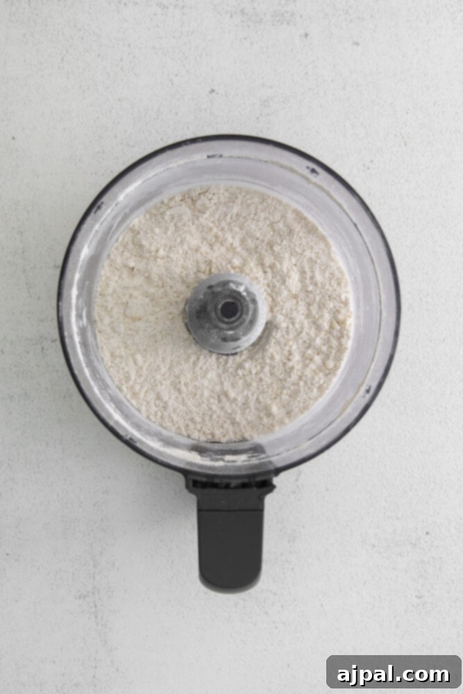 Flour being processed in a food processor, starting the homemade galette crust.