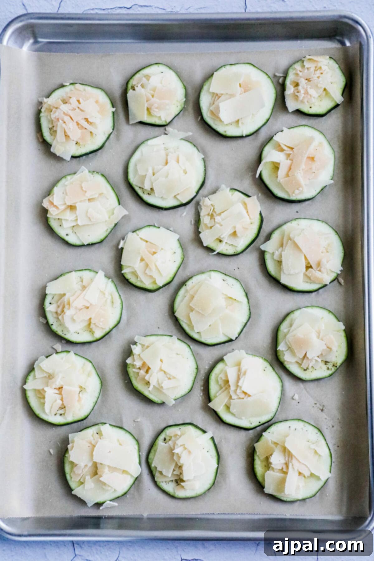 Parmesan Crusted Zucchini 7 picture of sliced zucchini with seasonings and parmesan on a baking sheet lined with parchment paper