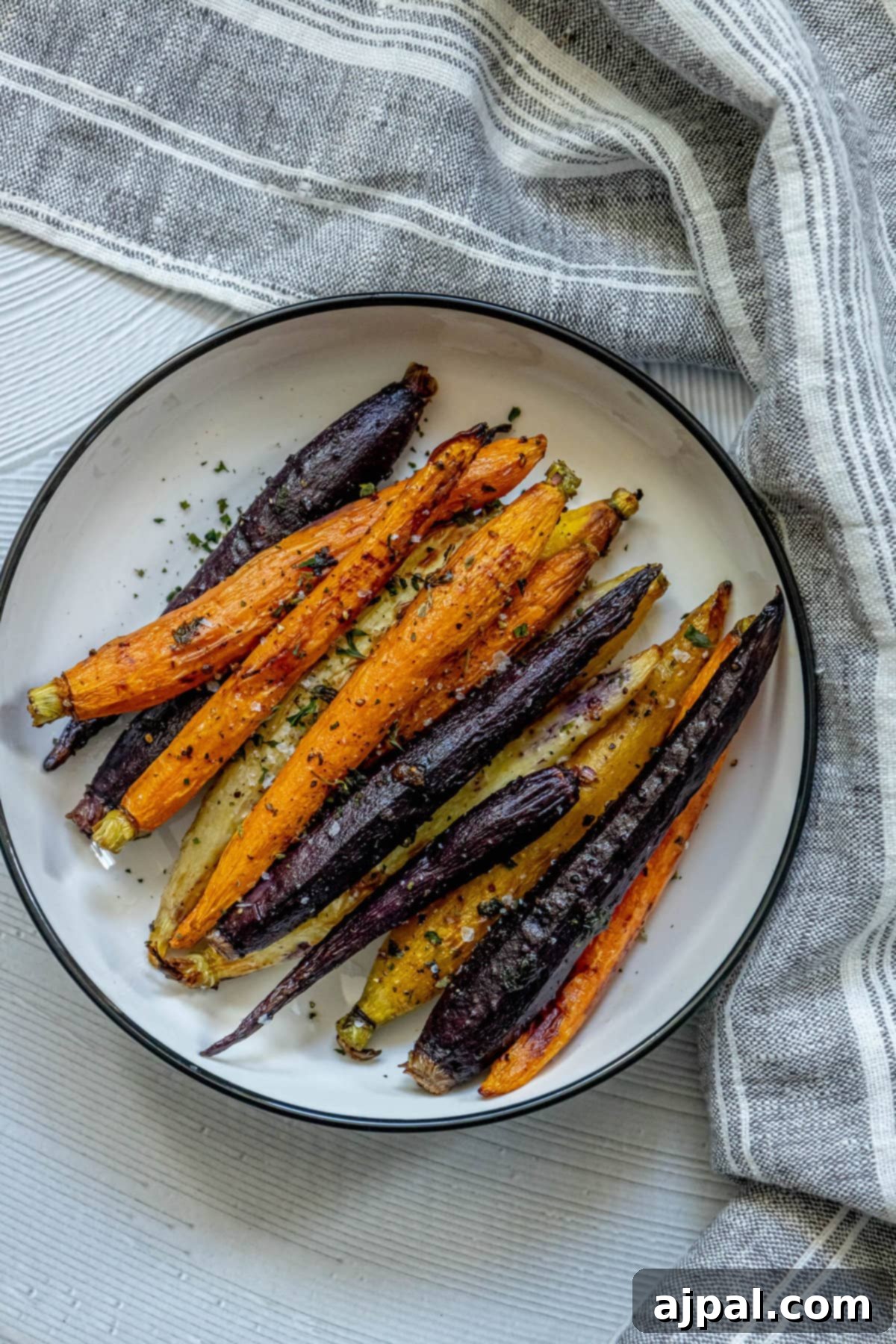 Roasted carrots on a white plate with a grilled twist.