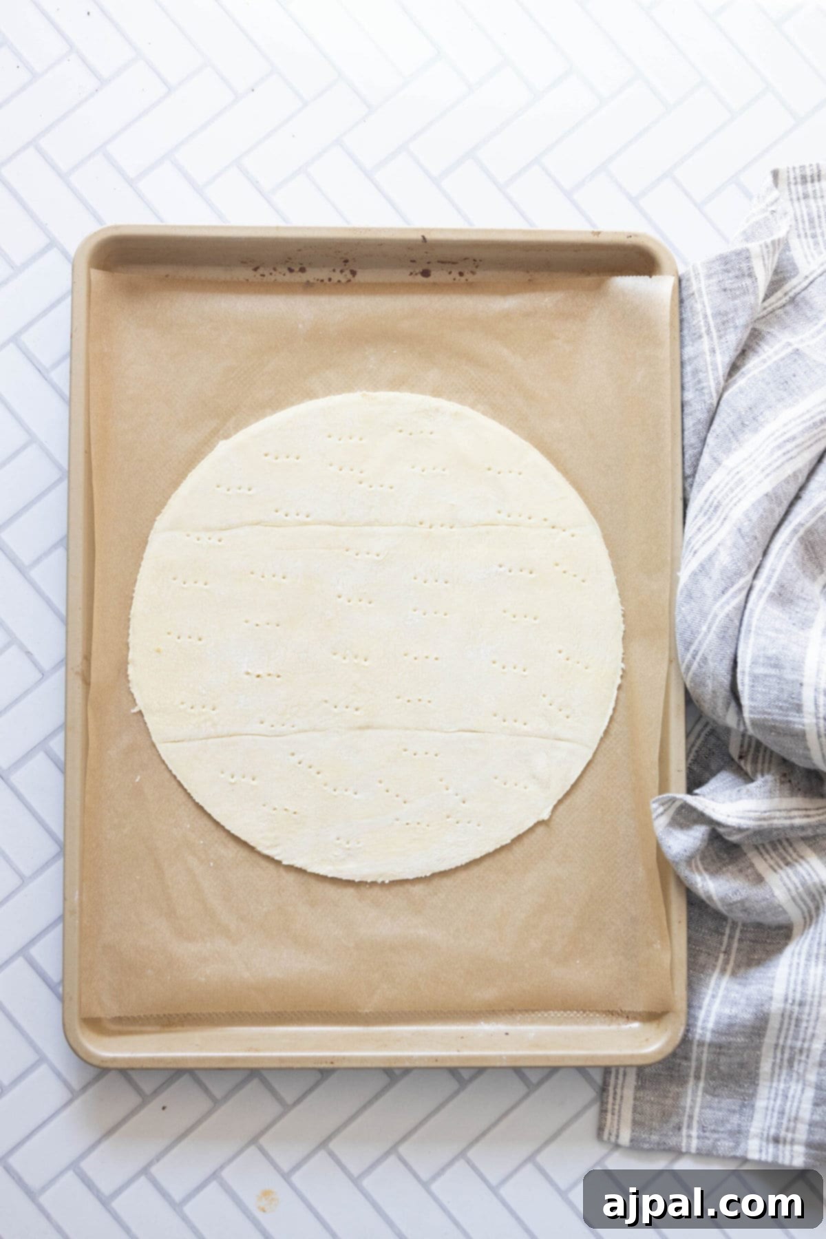 Simple Perfection: French Apple Tart 7 A pristine sheet of puff pastry dough, perfectly unrolled and ready for shaping, resting beside a clean kitchen towel on a baking surface, awaiting transformation into an Easy French Apple Tart.