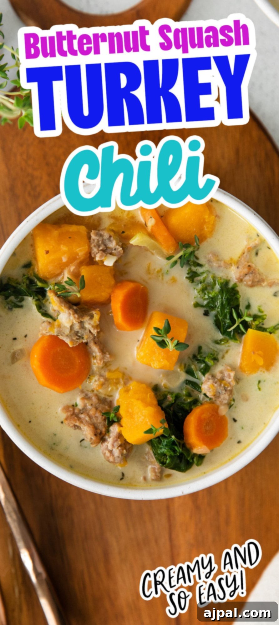 Autumn Harvest Turkey Chili 10 creamy turkey and butternut squash chili with carrots, thyme, kale, and peppers in a white bowl on a table