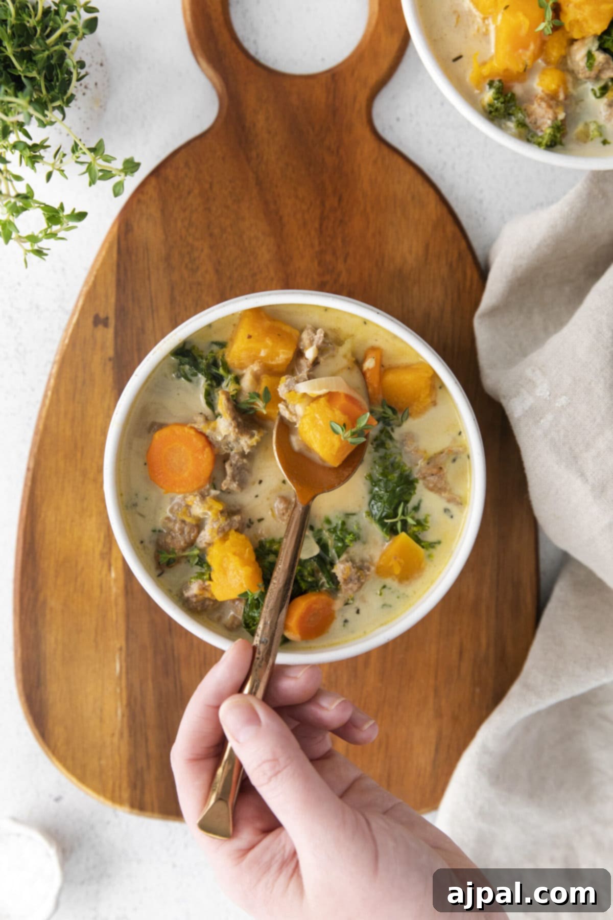 Autumn Harvest Turkey Chili 7 creamy turkey and butternut squash chili with carrots, thyme, kale, and peppers in a white bowl on a table