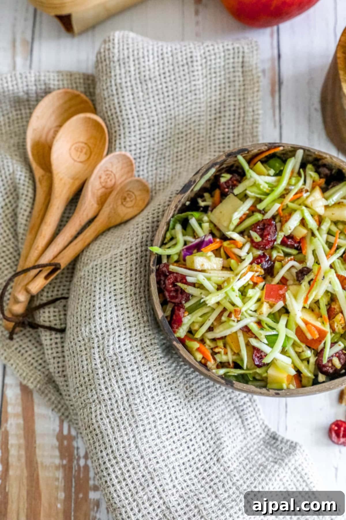 Sweet and Crunchy Cranberry Pecan Salad 2 Apple slaw in a bowl with wooden spoons, healthy cranberry pecan salad.