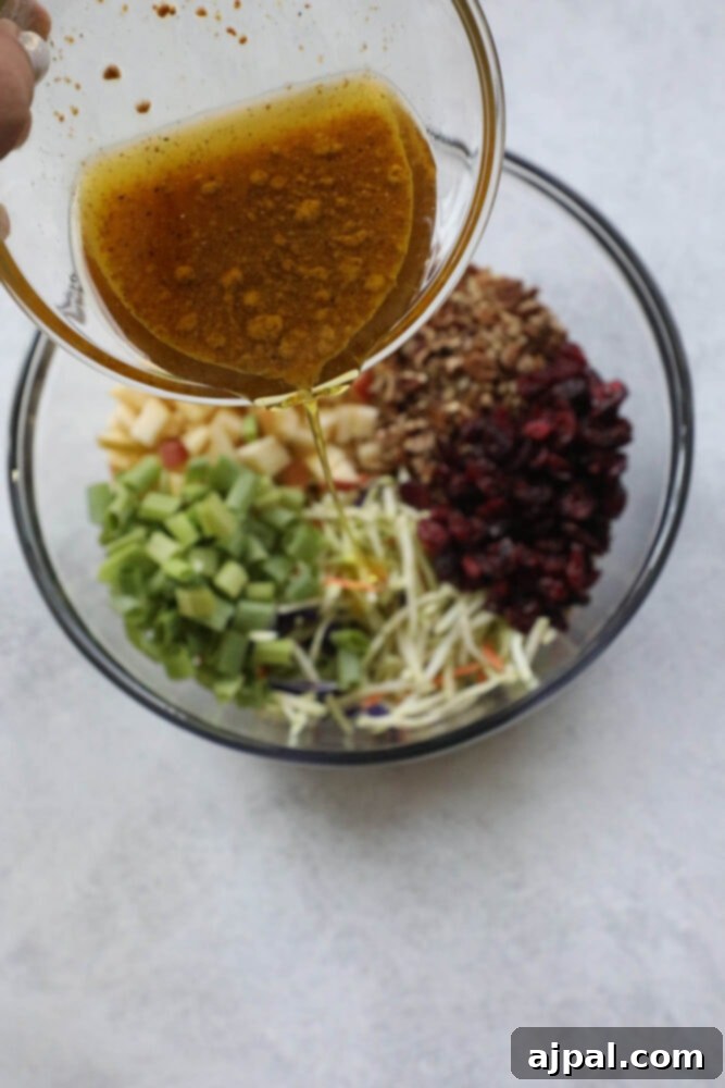 Sweet and Crunchy Cranberry Pecan Salad 5 picture of vinaigrette being poured into cranberry slaw salad