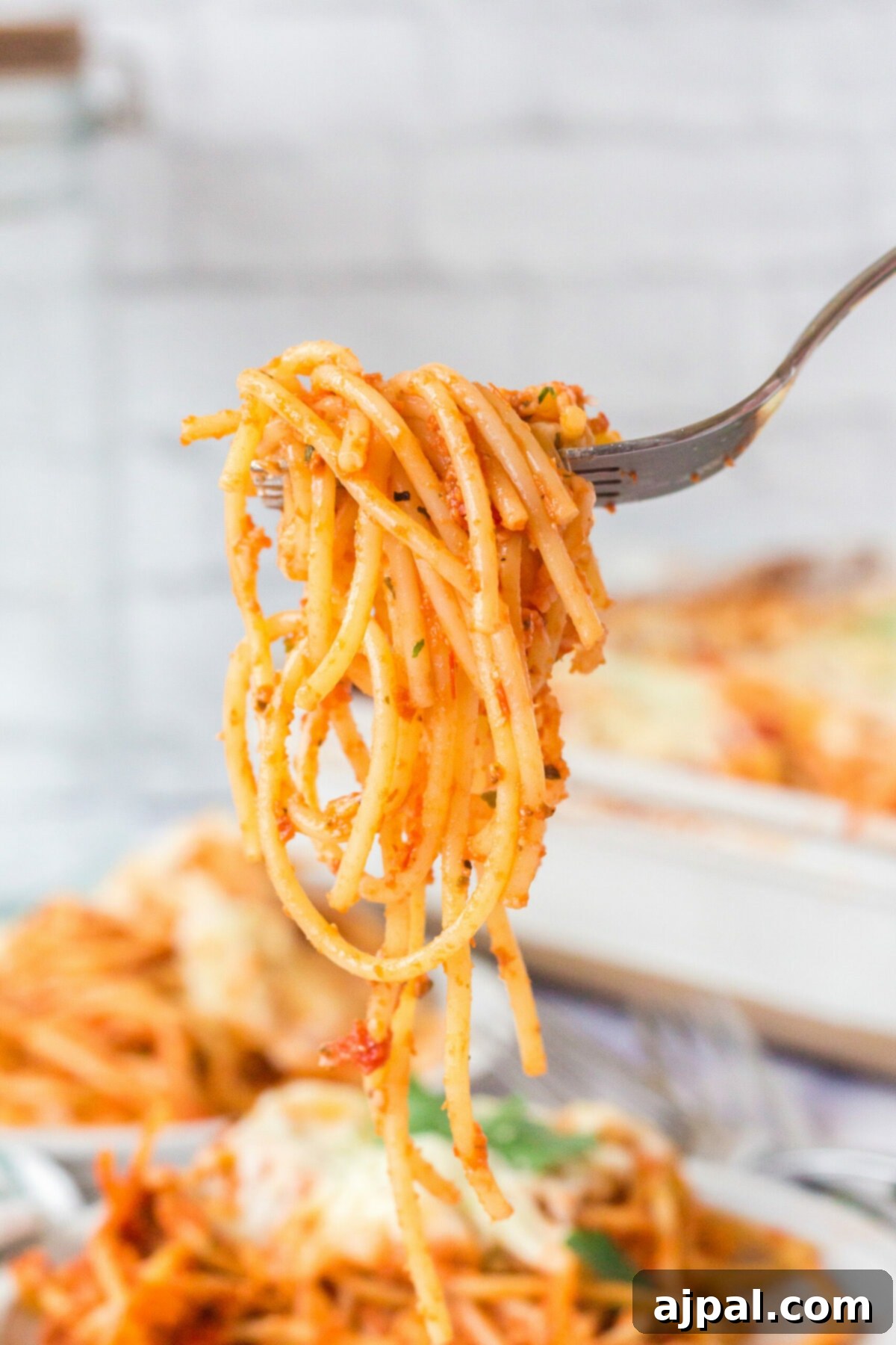 Ultimate Cheesy Spaghetti Bake 4 picture of baked spaghetti with melted cheese on a fork
