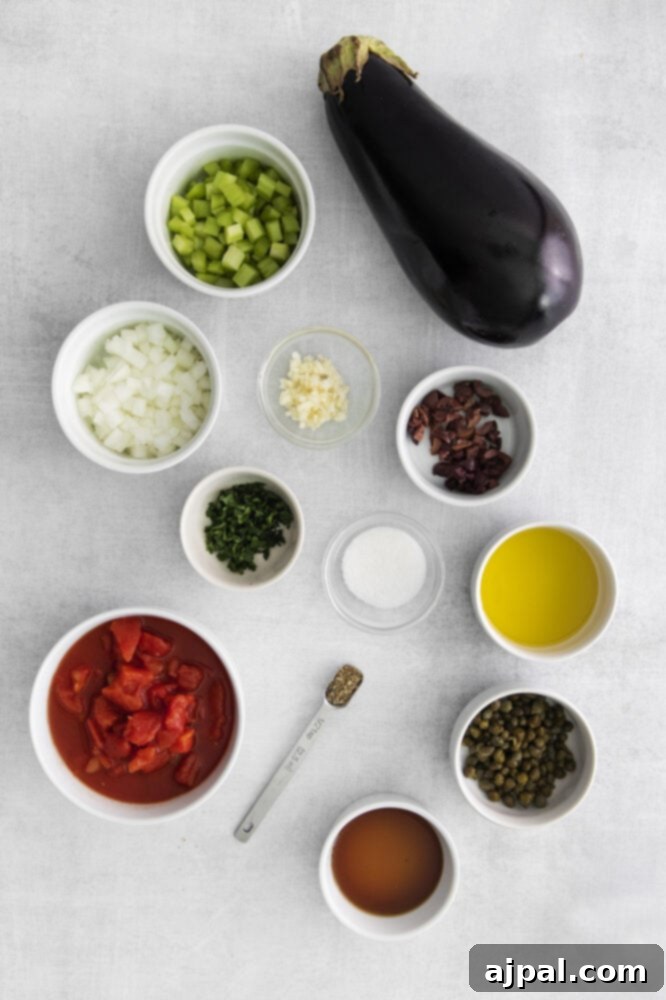 No-Fuss Eggplant Caponata 4 A colorful array of fresh ingredients including eggplant, onions, garlic, tomatoes, herbs, salt, and olive oil artfully arranged on a rustic wooden table, ready for cooking.