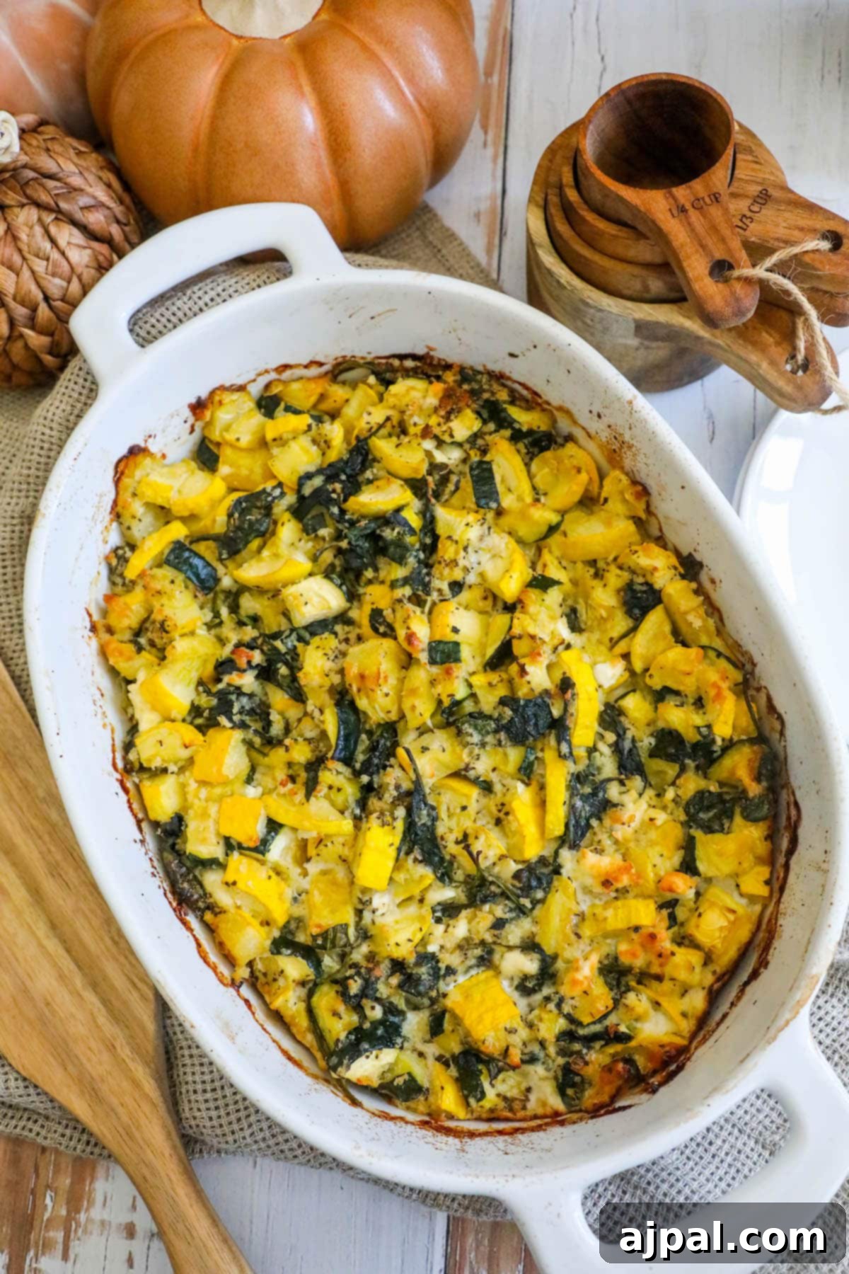 Green & Gold Feta Casserole 11 A freshly baked casserole of spinach, zucchini, and feta, golden and inviting, sits on a wooden table.