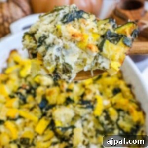 Green & Gold Feta Casserole 15 picture of spinach and zucchini feta baked casserole in a white dish with a spoon scooping it