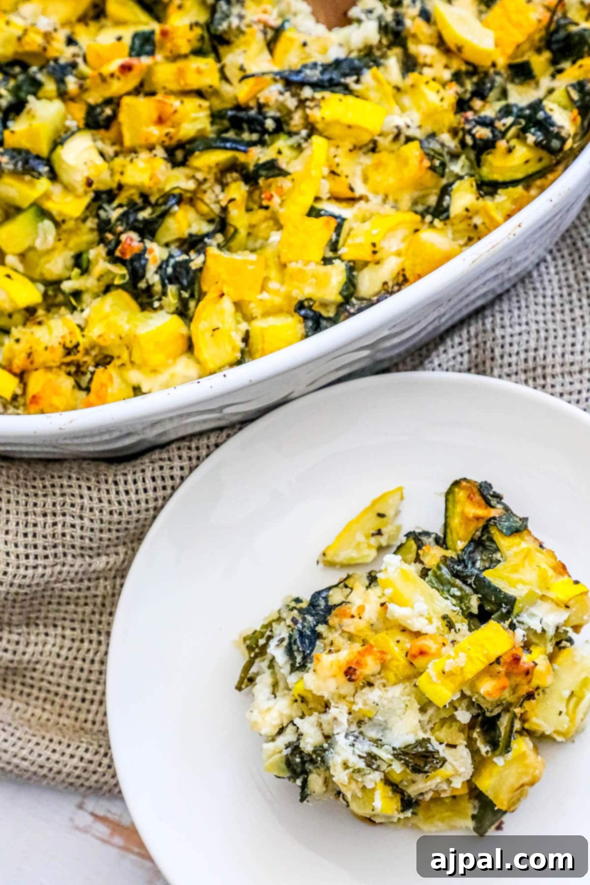 Green & Gold Feta Casserole 4 A serving of spinach, zucchini, and feta casserole on a white plate, showcasing the vibrant vegetables and melted cheese.