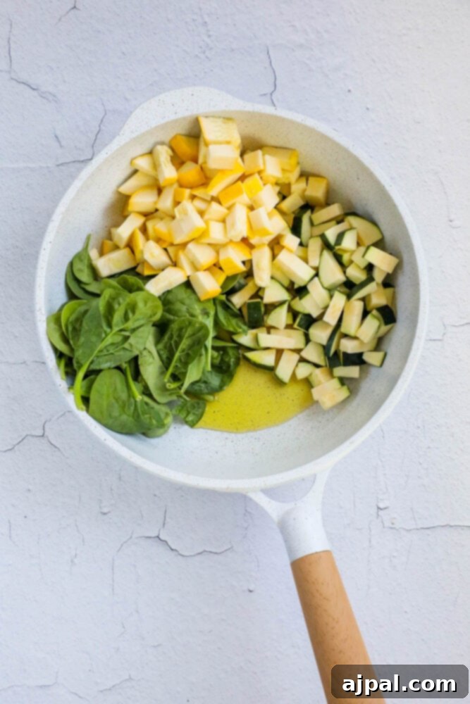 Green & Gold Feta Casserole 6 Olive oil, zucchini, spinach, and yellow squash sautéing together in a large pan, releasing their aromatic flavors.