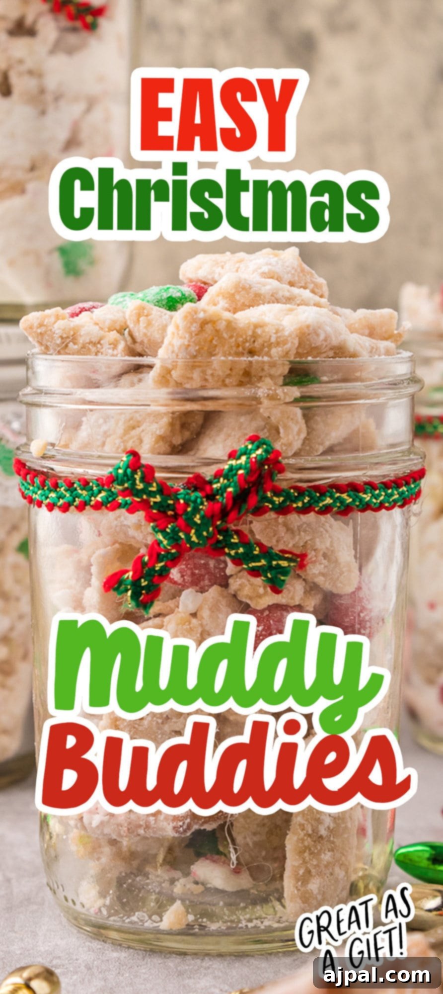 picture of muddy buddies chex mix with pretzels and red and green candies mixed in coated in powdered sugar in a jar with a red and green bow on it 