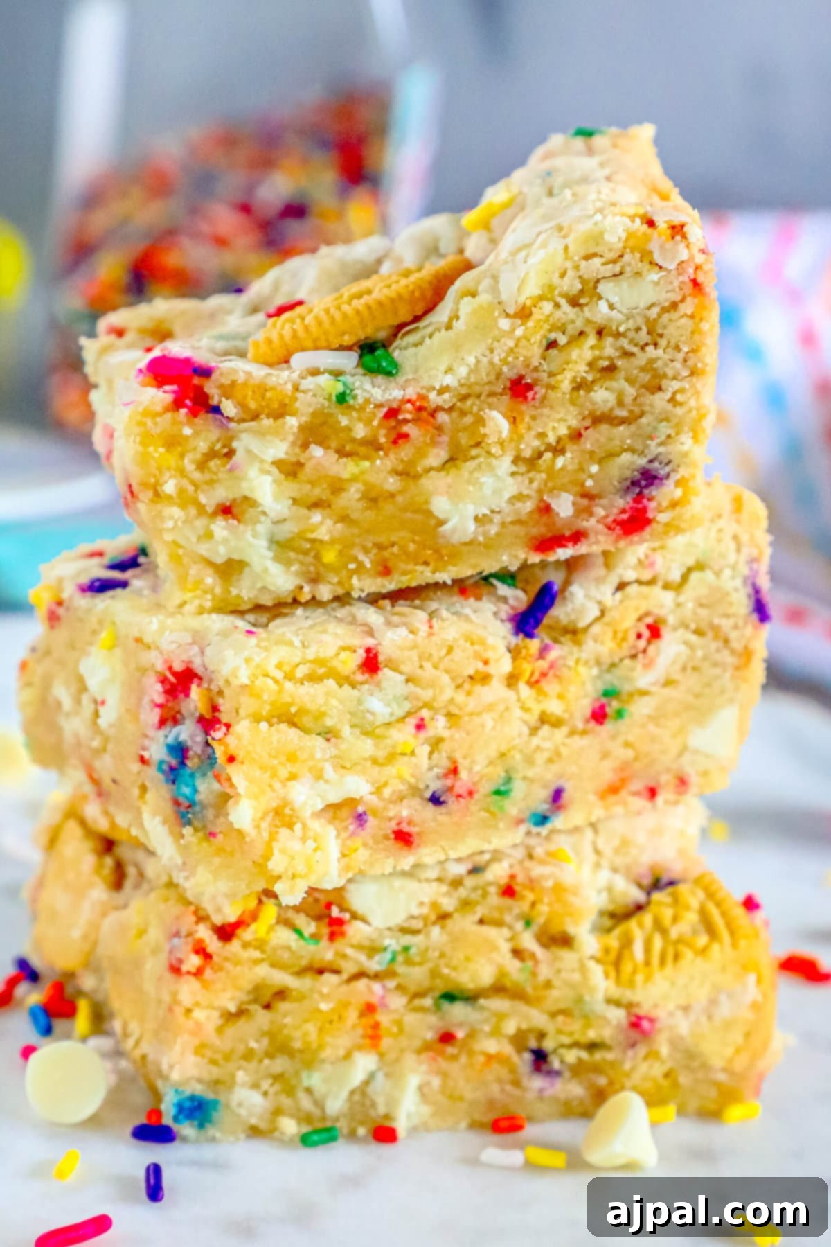 Chewy Funfetti Cookie Bars 2 funfetti cookie bars stacked on top of each other on a table, showcasing their colorful sprinkles