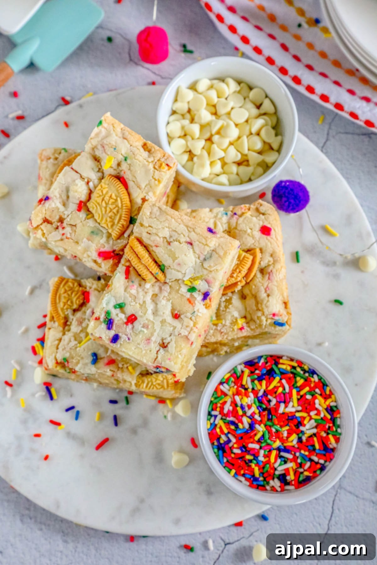 Chewy Funfetti Cookie Bars 3 funfetti cookie bars with colorful sprinkles on a white plate