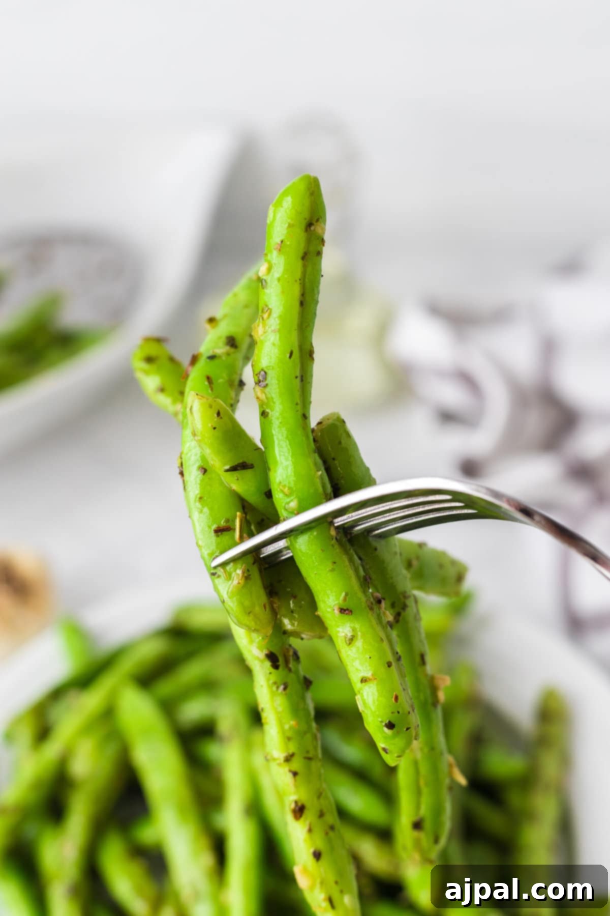 Garlic herb green beans presented on a fork, ready for tasting.