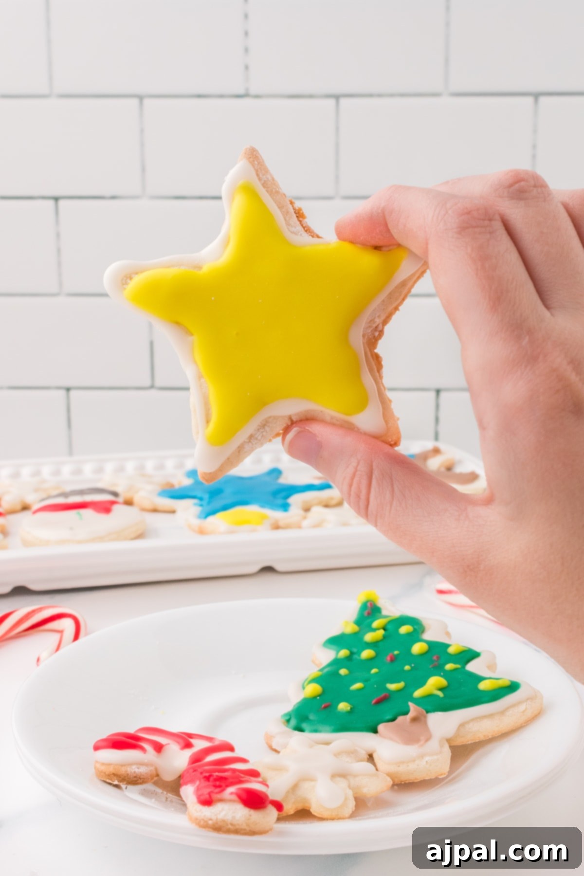 Simple Frosted Christmas Sugar Cookies 16 picture of a hand holding a star shaped iced sugar cookie