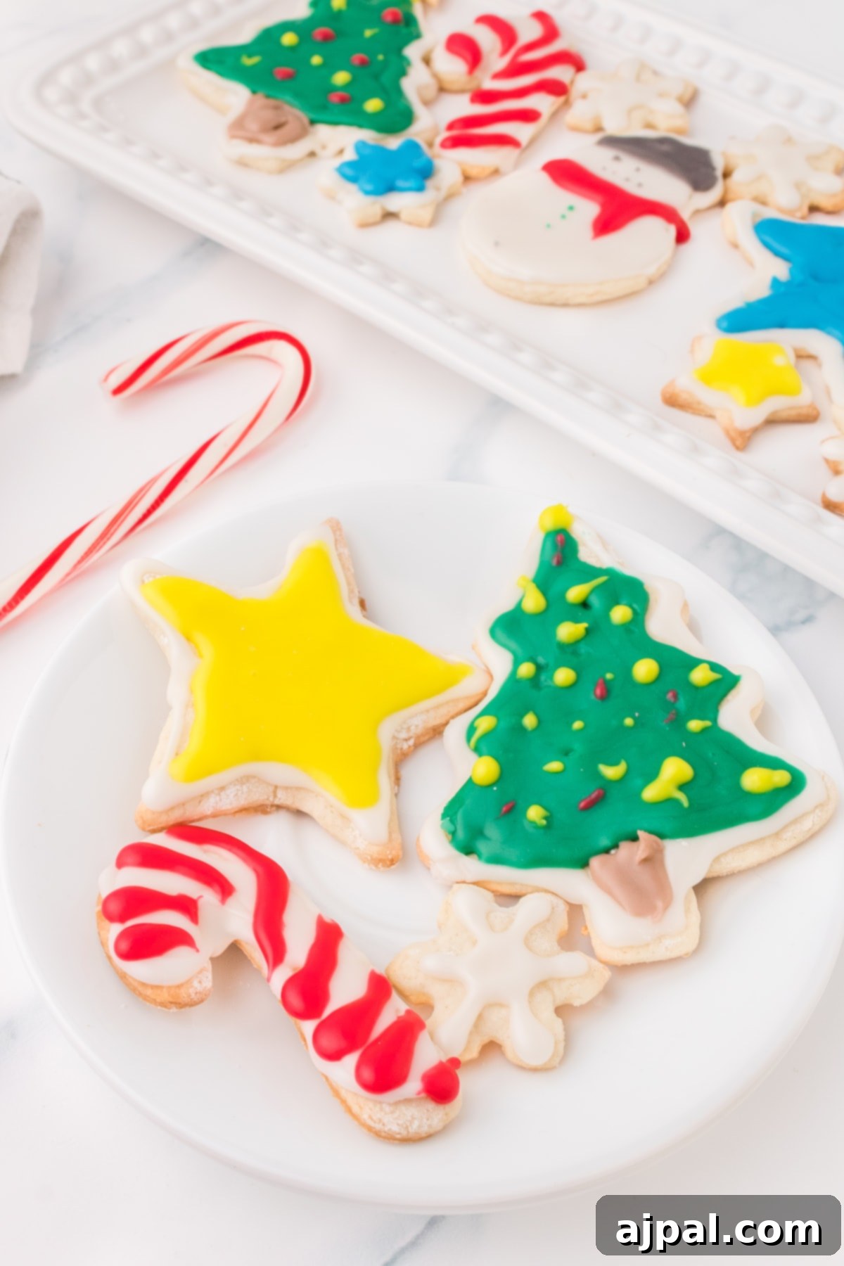 Simple Frosted Christmas Sugar Cookies 17 picture of iced christmas cookies on a white plate on a table