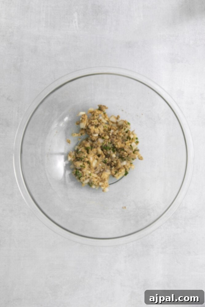 An air fryer meatloaf recipe utilizing a glass bowl with a mixture of ingredients.