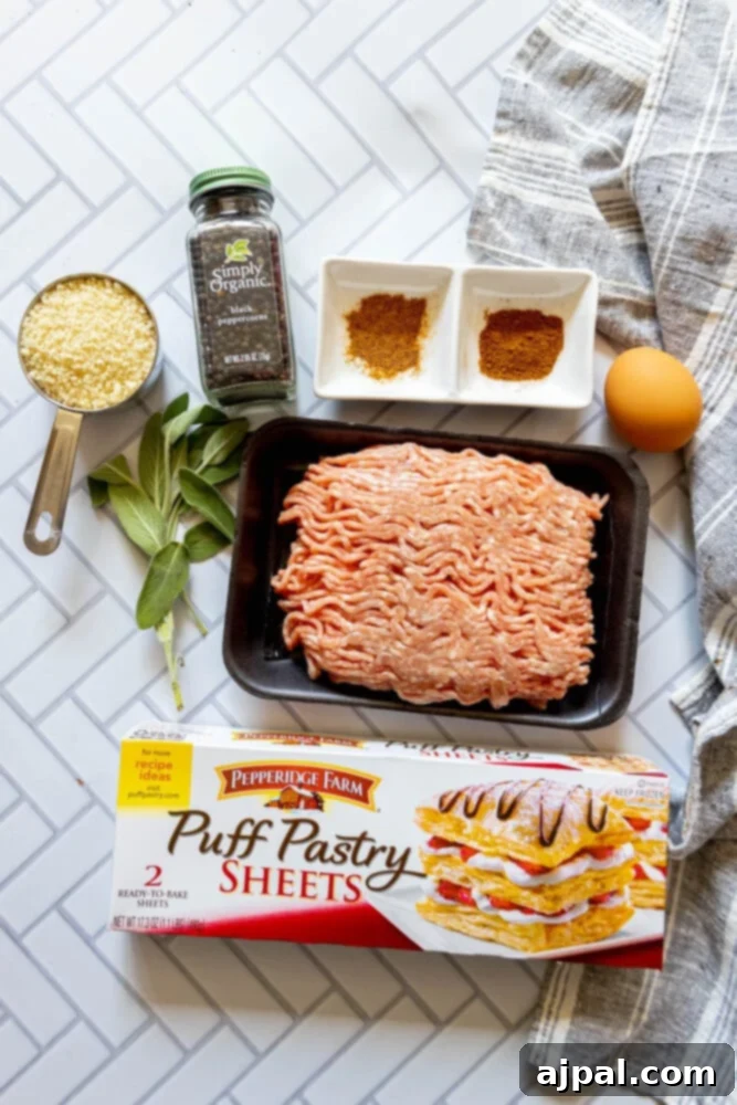 Classic English Sausage Rolls Recipe 5 All ingredients for easy British sausage rolls are neatly laid out on a tiled surface, featuring puff pastry, ground pork, breadcrumbs, and various herbs and spices.