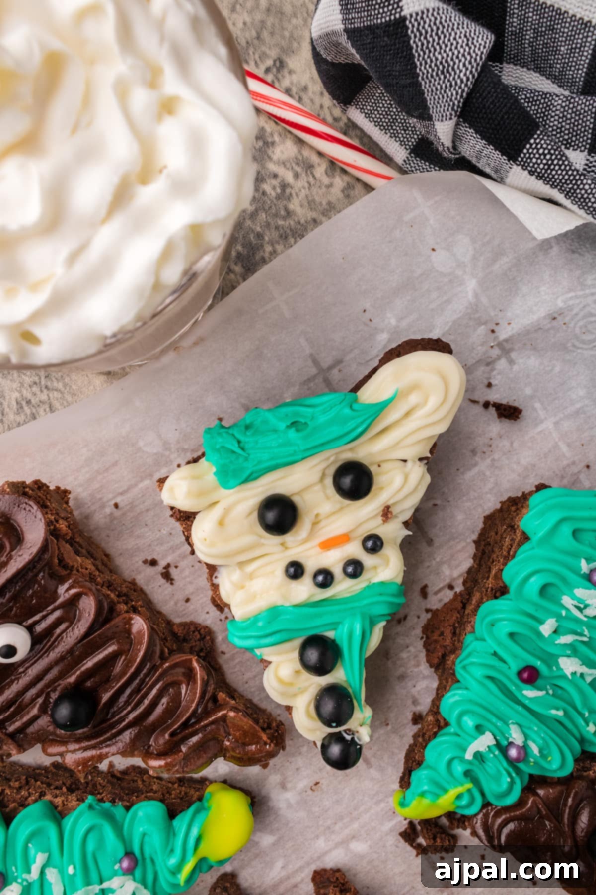 A delightful assortment of Christmas cookies, beautifully decorated with icing and whipped cream, arranged on a festive plate.