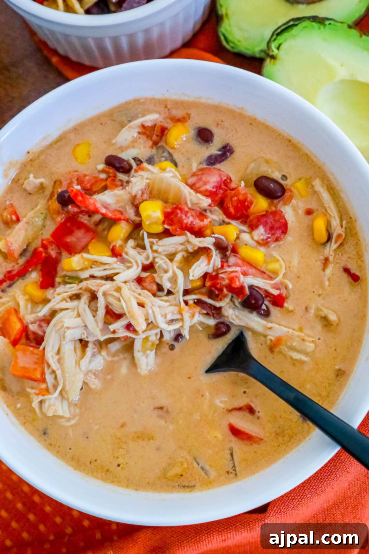 creamy chicken soup with beans, corn, rotel, and shredded chicken in a white bowl