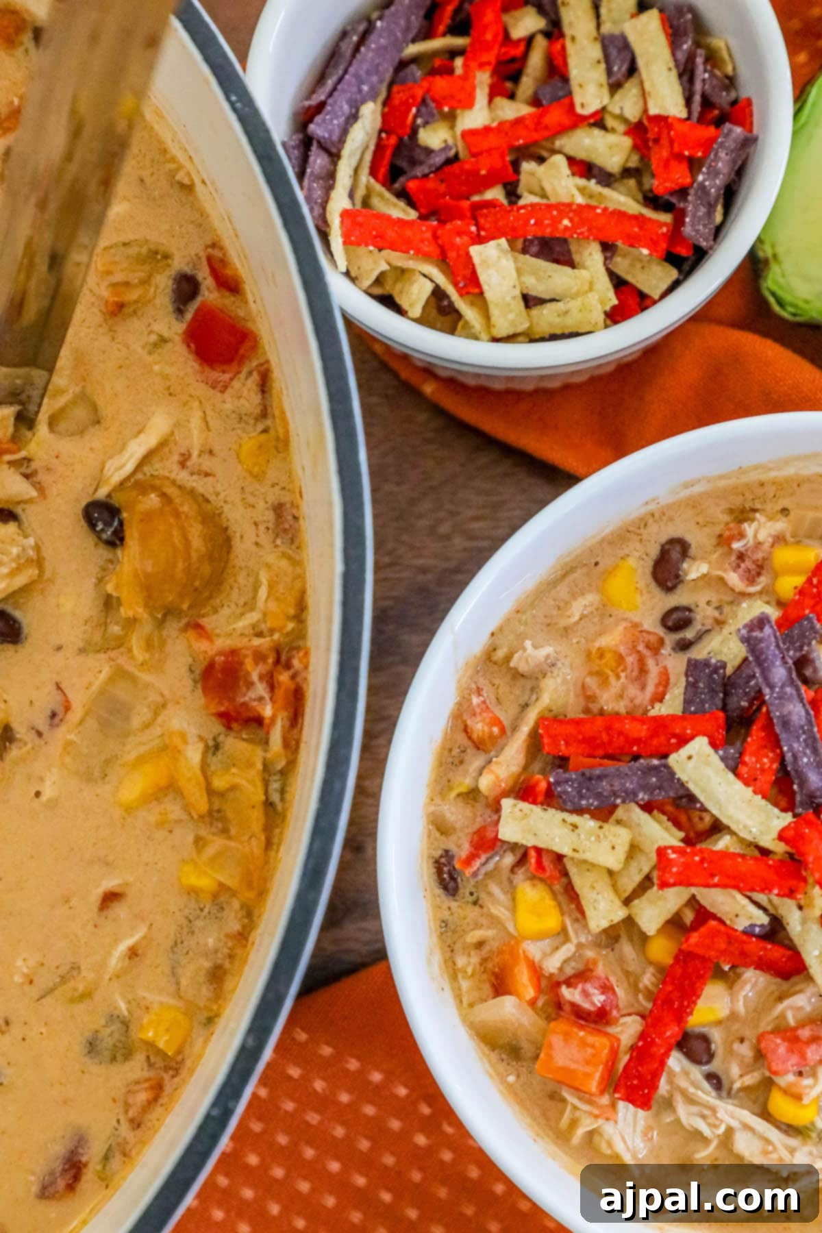 creamy chicken soup with beans, corn, rotel, and tortilla strips in a white bowl