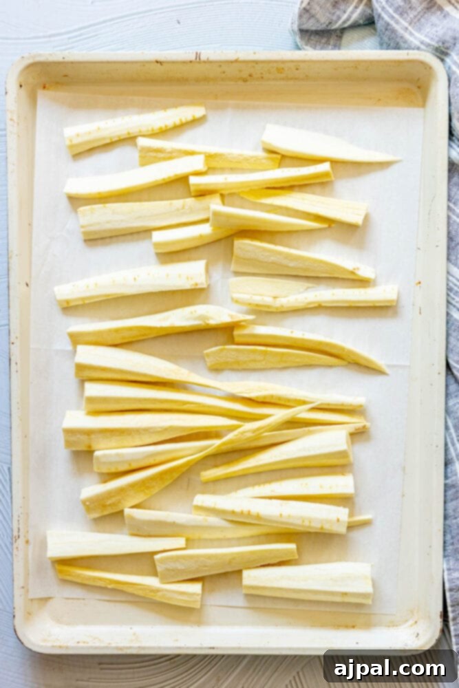 peeled and chopped parsnips on a baking sheet lined with parchment paper