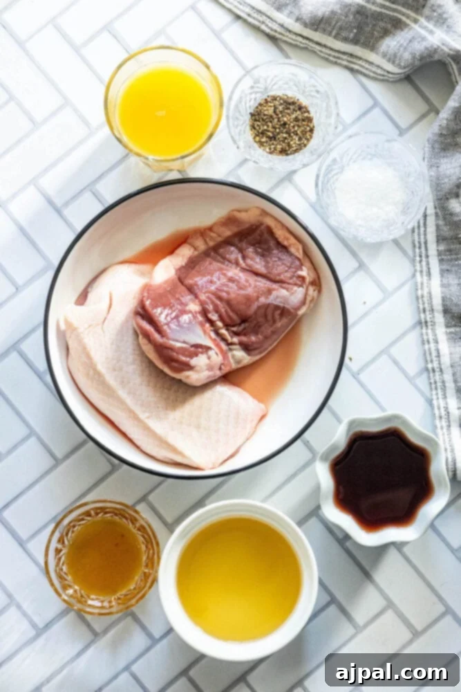 Golden-Crisp Duck Breast with Zesty Orange Reduction 3 Red wine, orange juice, honey, herbs, salt, pepper, and raw duck breast laid out on a rustic wooden table, ready for preparation.
