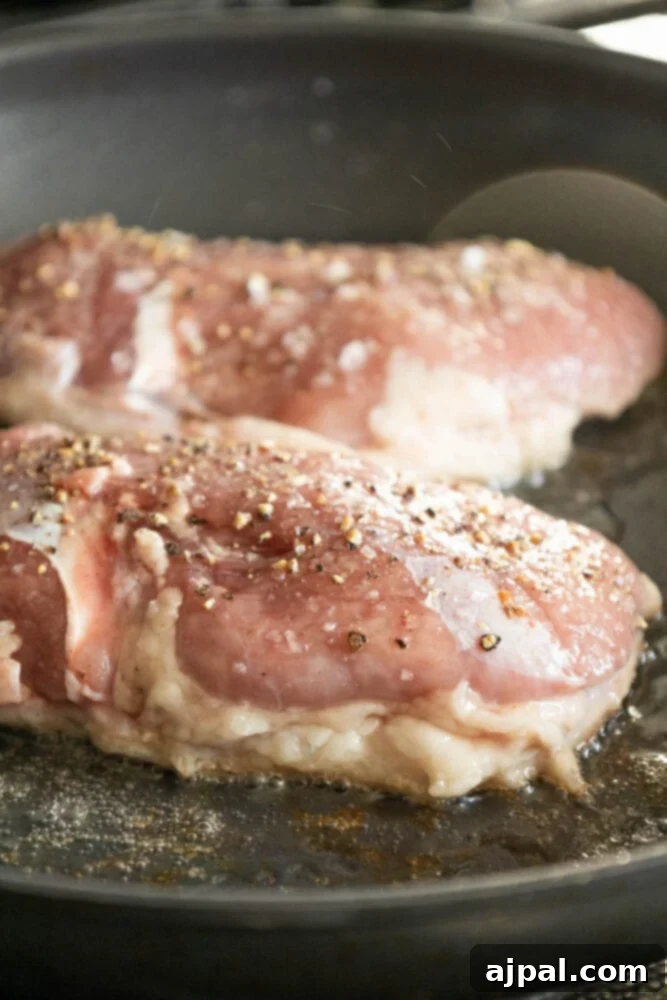 Golden-Crisp Duck Breast with Zesty Orange Reduction 4 Raw duck breast, fat-side down, beginning to sear in a hot pan, demonstrating the start of the rendering process.