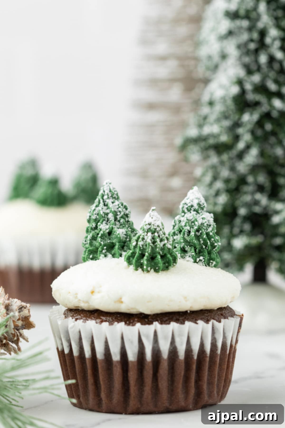 Winter mint chip Christmas cupcakes with icing and delicate pine cones, presented on a plate, ready for festive indulgence.
