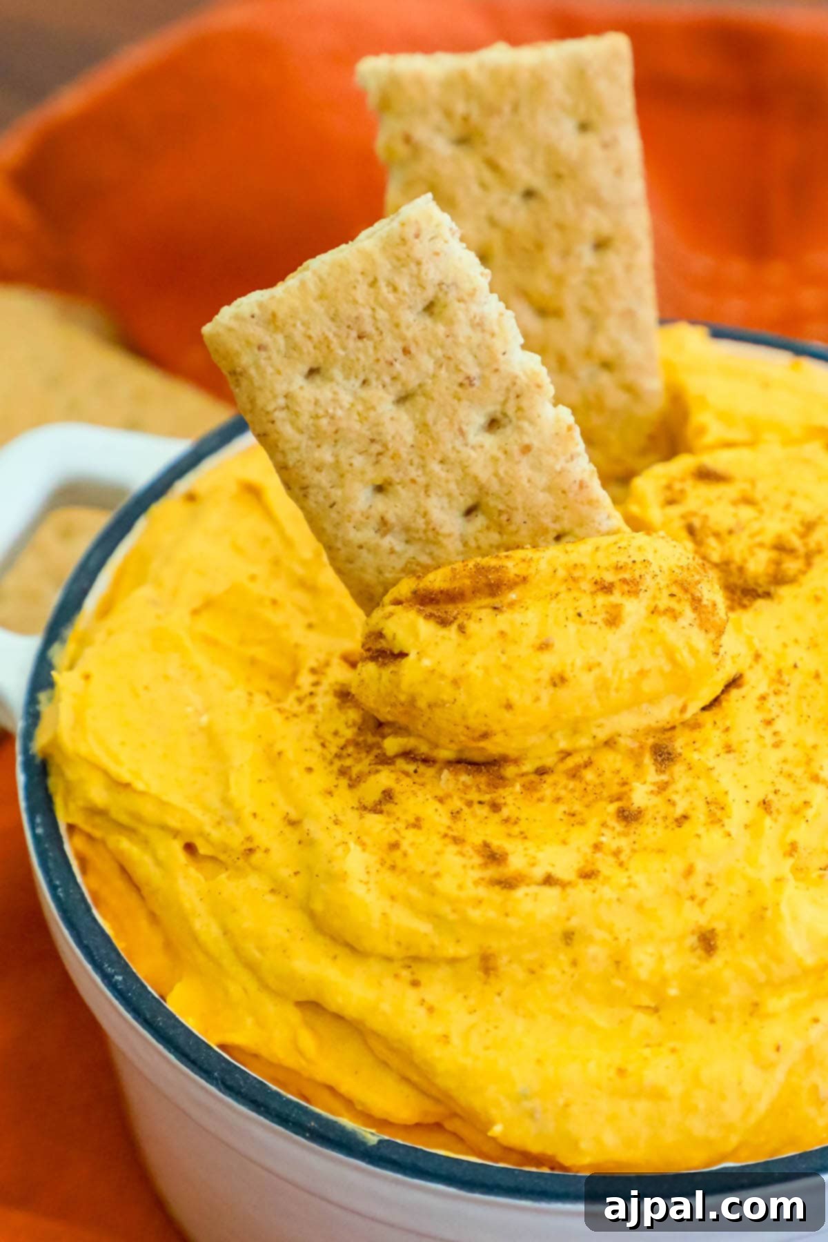 cool whip pumpkin pie fluff in a white bowl with graham crackers in it